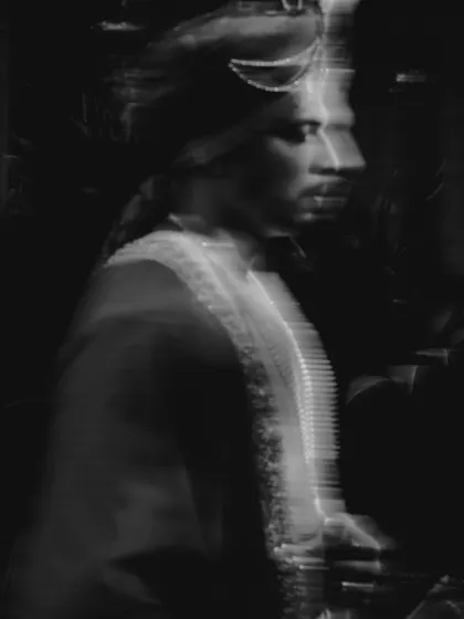 An artistic, motion-blurred portrait of the groom in black and white, conveying a sense of movement and energy.