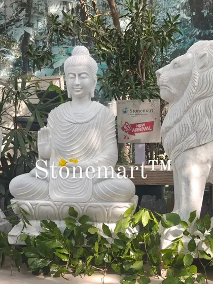The combination of the serene Buddha and powerful lions creates a unique and balanced aesthetic. These statues are carved from solid blocks of white marble and are built to withstand the elements.