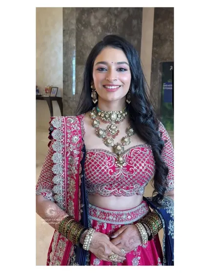 A happy, smiling portrait of Mithila at her reception. The goal is always to create a look that feels as good as it looks, allowing the client's personality to shine.
