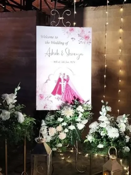 A personalized welcome sign featuring a lovely caricature of the bride and groom, surrounded by elegant white floral arrangements.