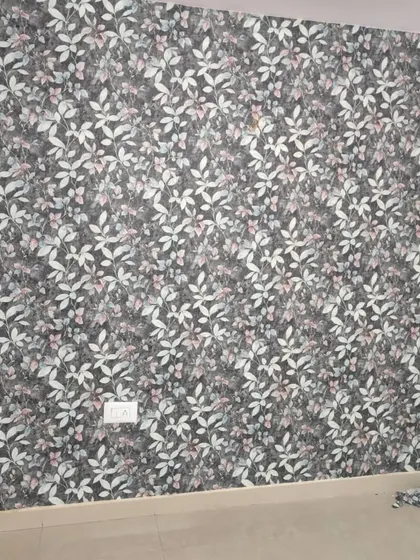 A dark wallpaper with a dense pattern of small, light-colored leaves. This design creates a sophisticated and moody look, perfect for a cozy bedroom or study.