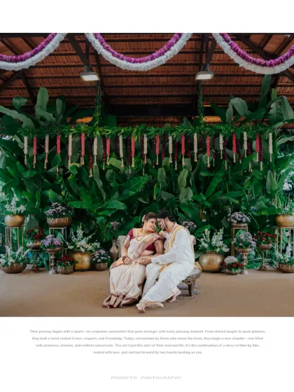 A breathtaking wide shot of the couple seated in front of a lush green backdrop, capturing the grandeur of their wedding decor.