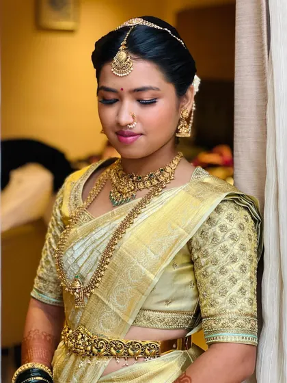 Another portrait of the bride in her light gold saree, showing the beautiful fit of the custom blouse and how it complements her traditional gold jewelry.