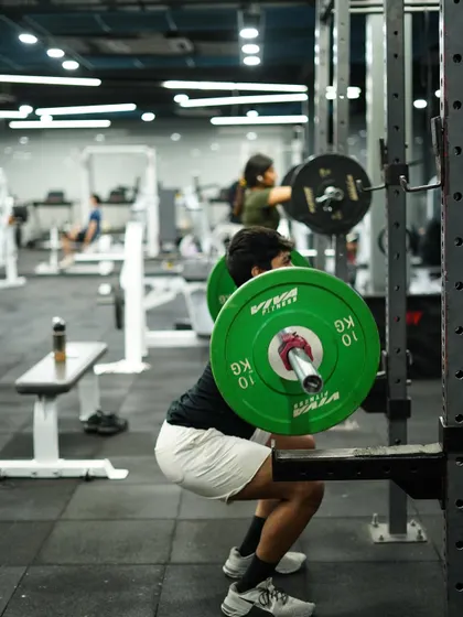 The squat is a cornerstone of strength. Here, a member demonstrates proper depth and form under load, building powerful legs and a strong core.