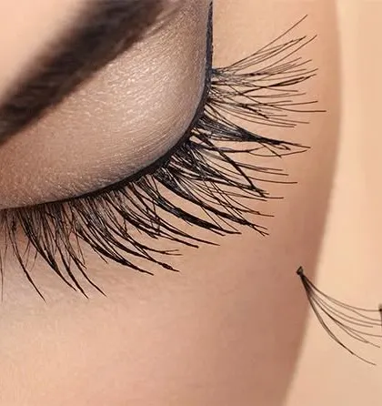 This macro image details our precision work. It shows a handmade lash fan just before it is applied to a single natural lash, which is the foundation of a beautiful volume set.
