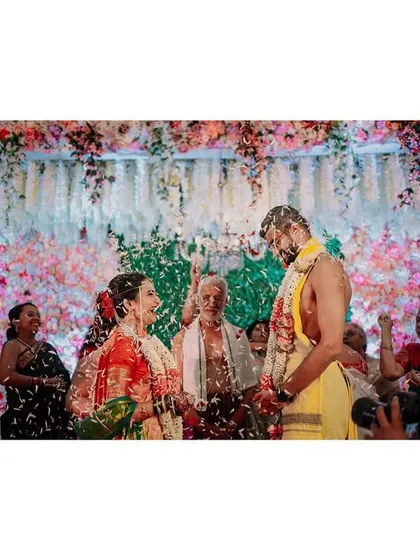 A panoramic collage of the akshata ceremony, where the couple is showered with rice and flower petals. The wide format captures the energy and joy of the moment from multiple angles.