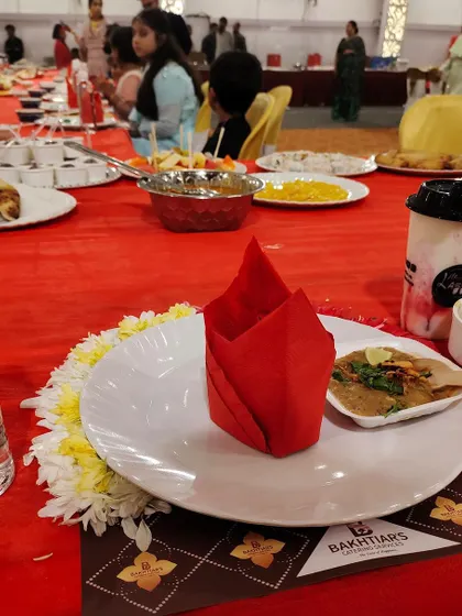 A close-up of a guest's place setting, featuring a serving of haleem. This highlights the small details and individual dishes that make up the larger feast.