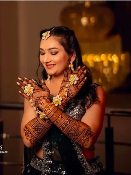 A lovely shot of a bride with her hands crossed, adorned with floral jewelry that matches her henna.