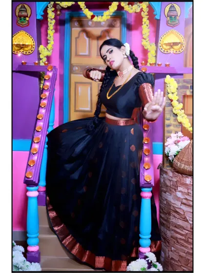 A confident pose in a traditional black and copper half-saree, perfect for capturing the essence of South Indian culture.