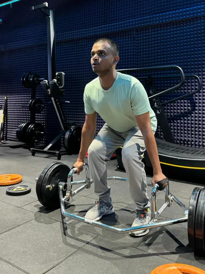 Here is the starting position for a trap bar deadlift. Notice how the client keeps his chest up and back flat, ready to drive through his legs to lift the weight. This form is crucial for a safe and powerful lift.