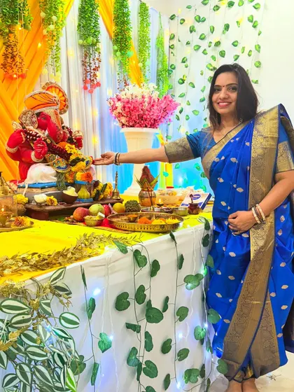 My Ganesh Chaturthi look, wearing a traditional blue saree in a dhoti style while performing aarti.