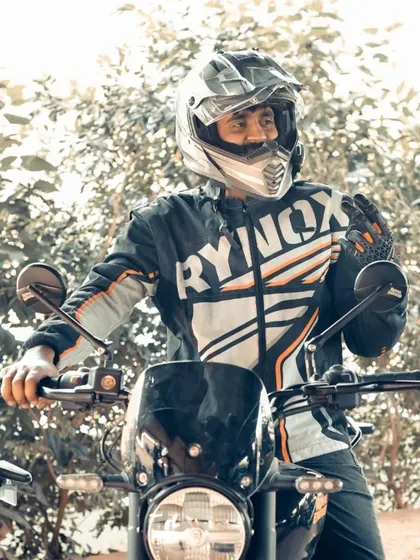A rider in full gear, captured in a moment of action. This shot highlights the dynamic nature of motorcycling and the protective Rynox jacket worn by the participant.