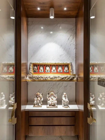A closer look at the home temple in the Filigree House. Enclosed in glass and rich wood, this space is a beautifully lit sanctuary for idols and spiritual items, designed with reverence and care.