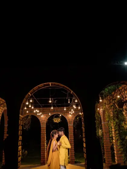 A wide-angle pre-wedding shot under the moonlight. The dramatic lighting and architecture create a feeling of romance and wonder.