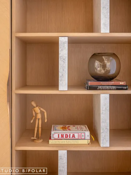 A close-up of the display unit, which is revealed when the sliding panels are closed. The light wood and subtle wallpaper inlay create an elegant and functional storage solution.