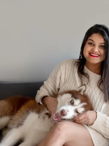A relaxed moment on the couch, showing the everyday bond between a pet parent and her gorgeous husky.