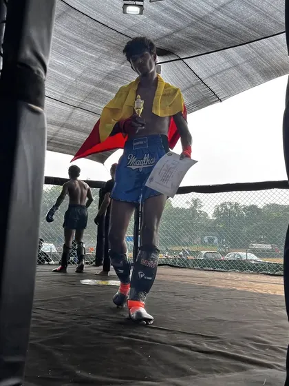 Karthik walking out of the cage with his trophy and the Karnataka flag after a knockout victory. A powerful image of a champion's exit.