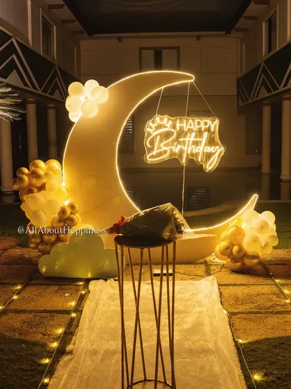 A detailed shot of the glowing moon backdrop at night. The combination of the neon sign and the lit-up moon shape is simply beautiful.