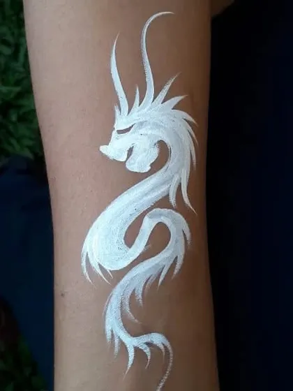 A striking white dragon temporary tattoo, painted on the arm.