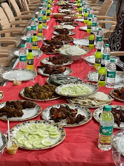 A close-up of the delicious spread at RR Party Hall in Maddur. You can see plates of sliced cucumbers, onions, chicken kebabs, and other starters, all part of our standard Dastarkhwan package.