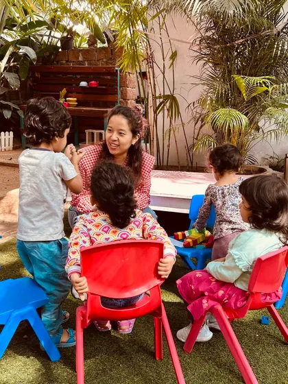 Storytelling is magic. Here, a Playmaker captivates a small group of children with a story, using expressive gestures and voices. These intimate moments build strong bonds and a deep love for literature.