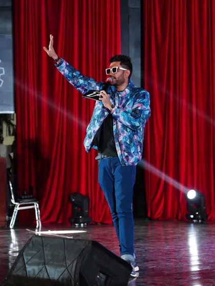 On stage is where I feel most alive. This shot captures the essence of my performance style: commanding, confident, and completely focused on connecting with every person in the audience.