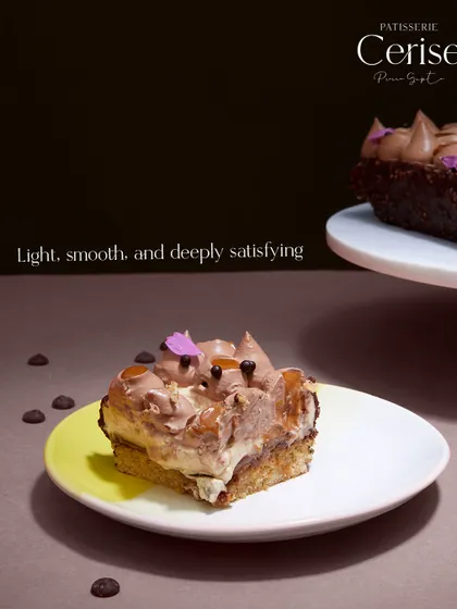 A slice of the "Go Nuts for Hazelnuts" on a plate. It's light, smooth, and deeply satisfying, showcasing the balance I strive for in my work.