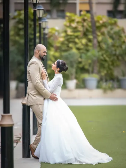 A full-length wedding portrait in a garden setting. The couple looks so elegant and happy in this classic, romantic shot.