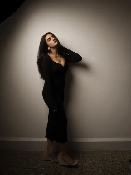 A studio session with a model in a black dress, showcasing a range of poses from pensive to powerful. The lighting is controlled to sculpt the subject and create a sophisticated mood.