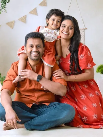 A beautiful family portrait in the boho-themed setting. The daughter on her father's shoulders adds a playful touch to this warm and rustic scene.