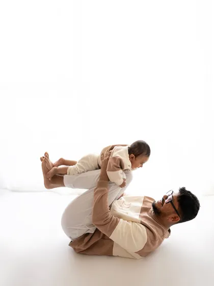 A father playfully lifting his baby in the air. This "airplane" pose is always a hit with the little ones and makes for a dynamic and joyful photo.