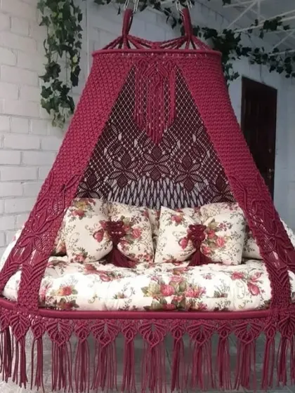 A beautiful maroon sofa swing with a floral mattress. This piece is perfect for adding a touch of traditional elegance and relaxation to your home.