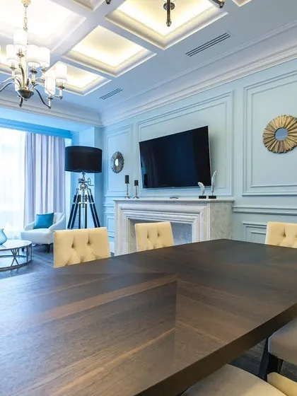 A stunning modern living and dining space in a striking blue and white color scheme. The room features a large dining table, a comfortable seating area, and a fireplace, all unified by the cool color palette.