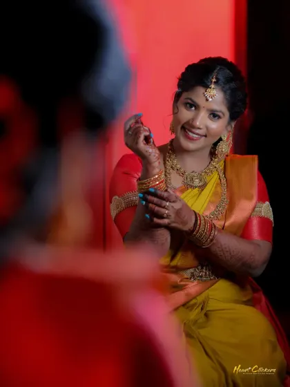 A creative portrait of the bride looking at her reflection, capturing a moment of self-admiration before the event.