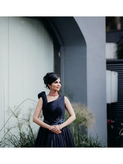 An elegant and modern reception style. The makeup is polished and sophisticated, designed to complement her one-shoulder gown and chic updo.
