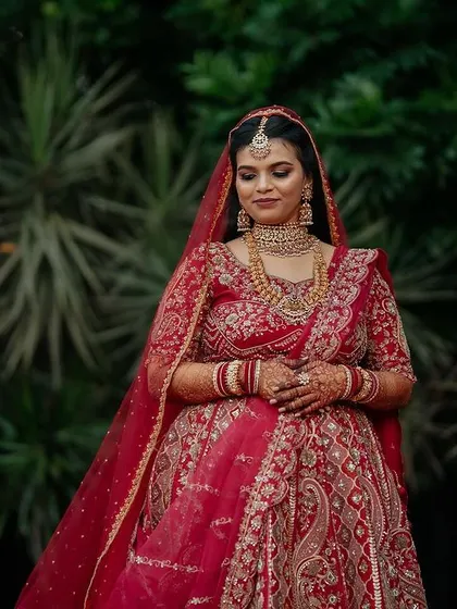 A regal bride in her magnificent red lehenga. We capture the grandeur of the bridal attire, creating portraits that are both powerful and elegant.