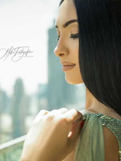 A serene, reflective portrait with the city of Dubai softly blurred in the background. This close-up focuses on mood and beauty, using the location as a subtle, high-end setting.