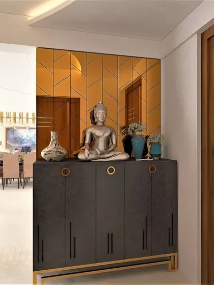 A luxurious foyer with a dark console table and a gold-tinted, geometric-patterned mirror wall. The Buddha statue adds a calming presence to the glamorous space.