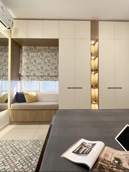 A perfect example of integrated design. This bedroom features a cozy bay window seat built right into the wardrobe unit, which also includes an open, lit display niche for personal treasures.