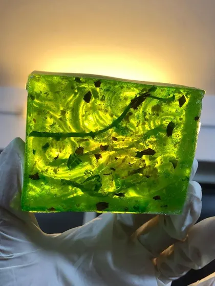A custom-ordered 'Hydration Station' soap, glowing in the light. This vibrant green bar is packed with moisturizing ingredients and has a beautiful, artistic swirl.