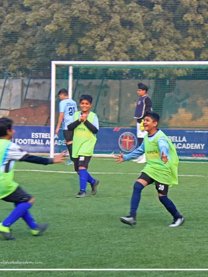 A moment of pure celebration between two players in bibs during a practice match. Teamwork and friendship are at the heart of our academy's culture.