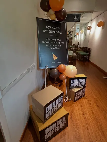 The 'Dunder Mifflin' party entrance featured a welcome sign from the "party planning committee" and stacks of branded paper boxes, setting the tone for 'The Office' theme.