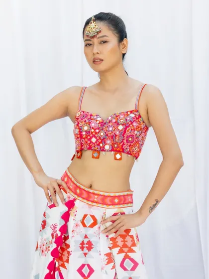 This is a classic e-commerce shot, providing a clear and direct view of the product. The model's confident pose and the clean white background ensure that the focus remains entirely on the colorful and detailed two piece outfit.