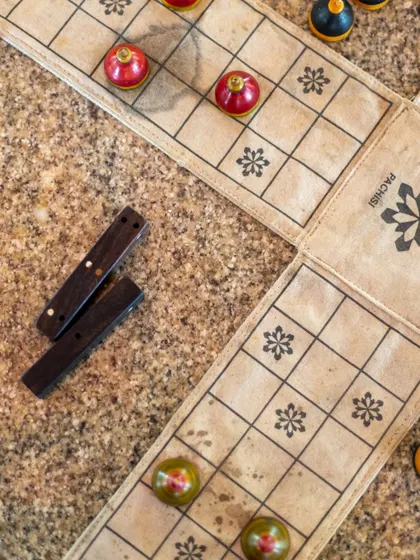 The colorful pieces of Pachisi, an ancient Indian cross and circle game, are laid out and ready for play.