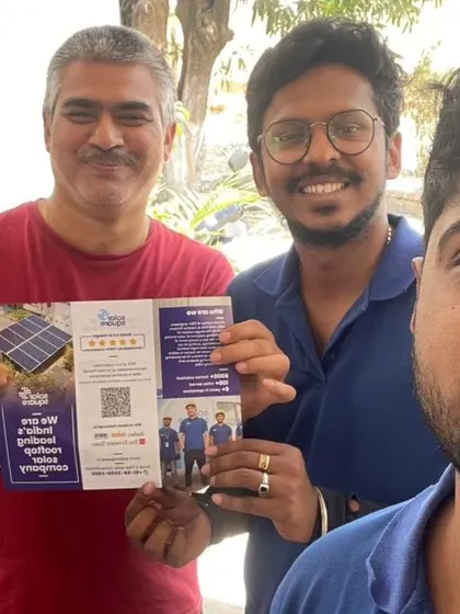 Our team with a customer holding our solar brochure.