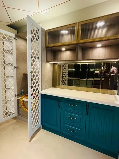 A display at my experience center showing a teal crockery unit next to a white pooja unit with beautiful jaali doors.