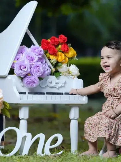 The happiest little musician. This outdoor first birthday shoot with a miniature piano captures a moment of pure, candid joy.