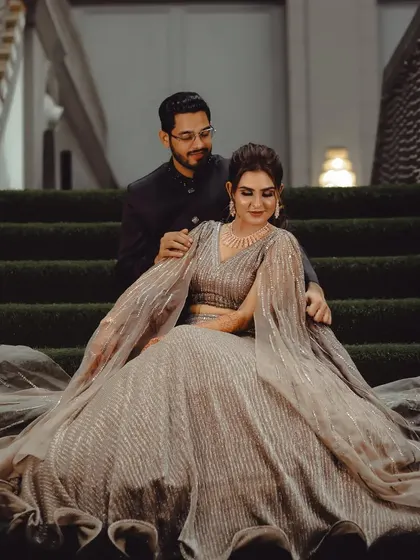 A romantic portrait of an engaged couple seated on a staircase, capturing a quiet moment together during their celebration.