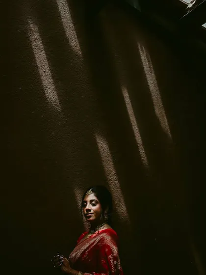 An artistic bridal portrait using dramatic shadows. The light falls on the bride in a way that creates a thoughtful and mysterious mood.