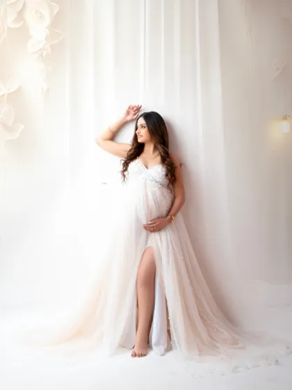 A quiet moment of contemplation. This portrait uses soft lighting and a simple white curtain backdrop to create an intimate and timeless feel.